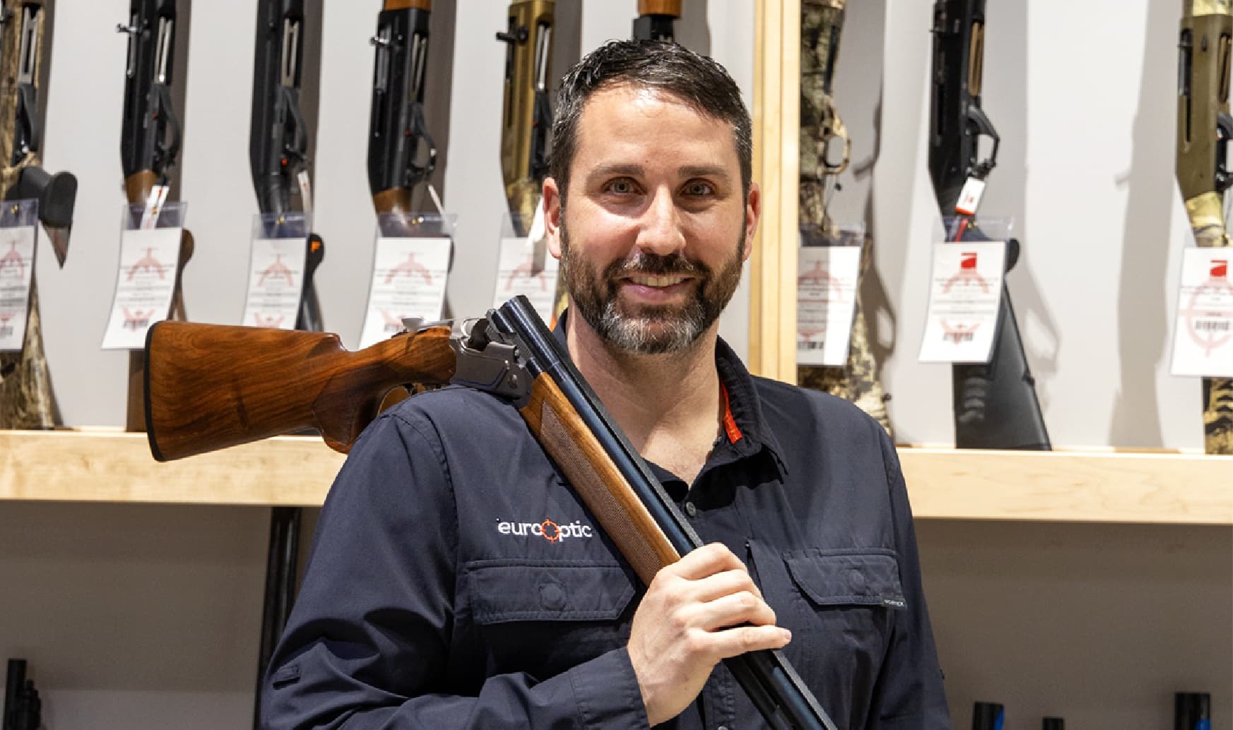 A picture of Josh holding a break action shotgun over his shoulder.